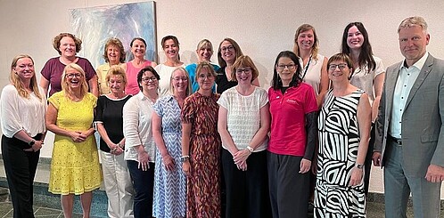 Gruppenbild von Frauen und Männern in formaler Kleidung