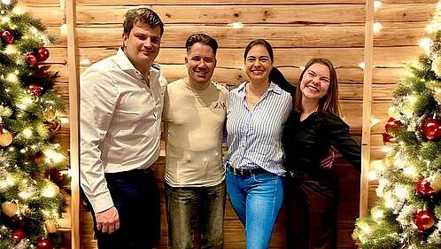 Das Foto zeigt die vier Mitglieder der AG Europa. Rechts und links von der Gruppe steht jeweils ein Weihnachtsbaum.