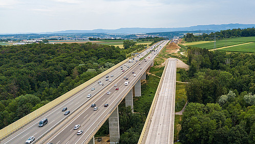Aerial view of a German Autobahn with construction works for a new railway bridge besides. Drone photo taken at Denkendorf near Stuttgart - on a weekend, hence not much truck traffic.