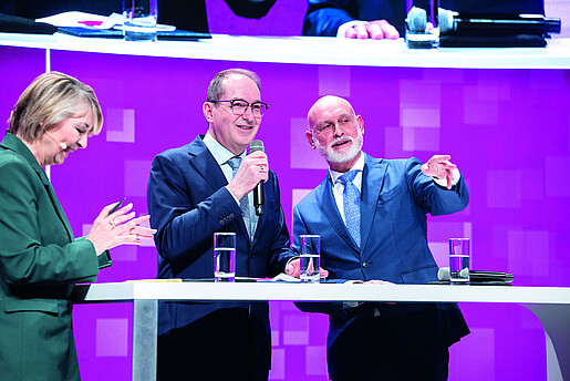 Zwei Menschen stehen auf einer Bühne und diskutieren miteinander. Es handelt sich um Bundesinnenminister Alexander Dobrindt und dbb-Chef Volker Geyer