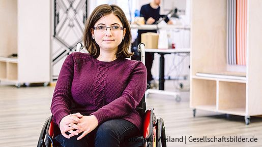 Junge Frau im Rollstuhl am Arbeitsplatz
