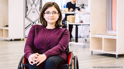 Junge Frau im Rollstuhl am Arbeitsplatz