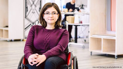 Junge Frau im Rollstuhl am Arbeitsplatz