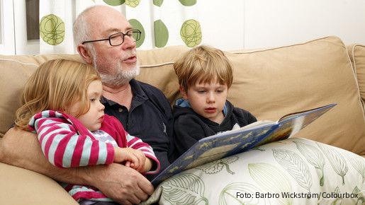 people, person, scandinavian, adult, child, male, man, senior, grandfather, grandparent, girl, boy, grandchild, group, age, 60, 3, 5, sitting, sofa, inside, indoors, livingroom, home, daylight, family, generation, togetherness, love, harmony, loving, reading, book, story, telling, enjoying, feeling, tenderness, happiness, happy, joyful, joy, entertainment, entertaining, blond, grey, casual, relaxed, relaxing, lifestyle, wellness