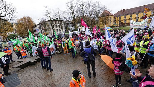 Menschen mit bunten Fahnen demonstrieren auf dem Platz des 17. Juni in Osnabrück.