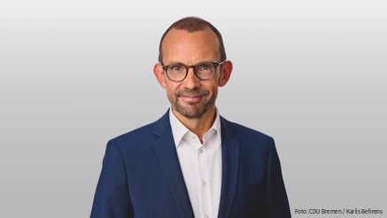 Foto von einem weißen Mann mit Anzug und Brille, der in die Kamera blickt. Es handelt sich um Thomas Röwekamp, Vorsitzender des Verteidigungsausschusses des Deutschen Bundestages 