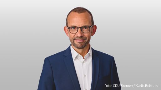 Foto von einem weißen Mann mit Anzug und Brille, der in die Kamera blickt. Es handelt sich um Thomas Röwekamp, Vorsitzender des Verteidigungsausschusses des Deutschen Bundestages 