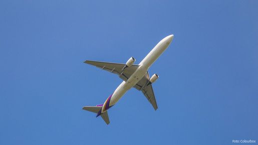 Zu sehen ist ein Flugzeug am Himmel