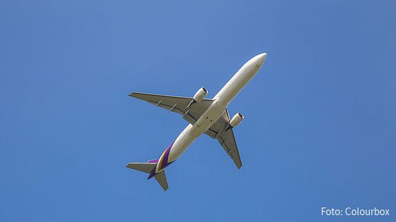 Zu sehen ist ein Flugzeug am Himmel