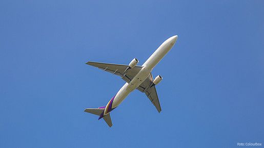 Zu sehen ist ein Flugzeug am Himmel