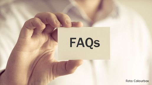 Closeup on businessman holding a card with text FAQs , business concept image with soft focus background and vintage tone