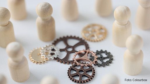 Wooden figures of people with metal gears close up. Hire personnel, team building, teamwork concept. People connection in business.
