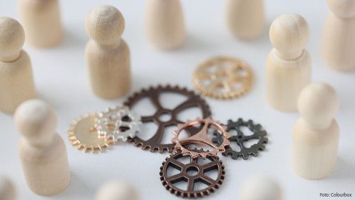 Wooden figures of people with metal gears close up. Hire personnel, team building, teamwork concept. People connection in business.