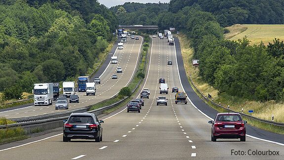 Das Foto zeigt Autos von hinten auf einer dreispurigen Autobahn.