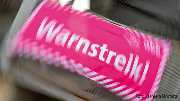 Foto eines neon-pinken Banners, auf dem in weißer Schrift "Warnstreik!" steht