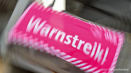 Foto eines neon-pinken Banners, auf dem in weißer Schrift "Warnstreik!" steht