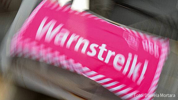 Foto eines neon-pinken Banners, auf dem in weißer Schrift "Warnstreik!" steht