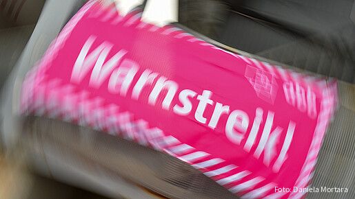 Foto eines neon-pinken Banners, auf dem in weißer Schrift "Warnstreik!" steht