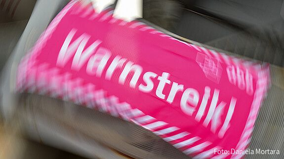 Foto eines neon-pinken Banners, auf dem in weißer Schrift "Warnstreik!" steht