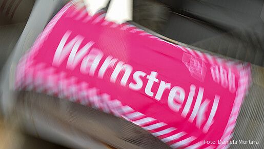 Foto eines neon-pinken Banners, auf dem in weißer Schrift "Warnstreik!" steht