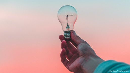 Eine Glühbirne wird ins Licht gehalten