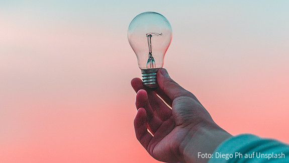 Eine Glühbirne wird ins Licht gehalten