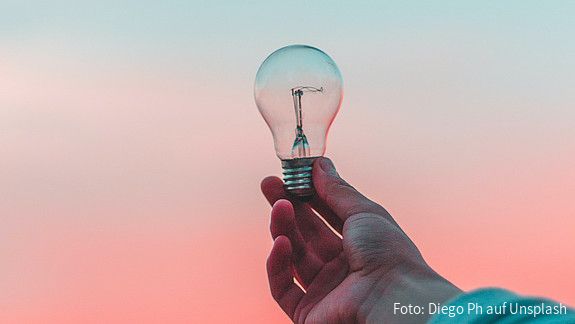 Eine Glühbirne wird ins Licht gehalten