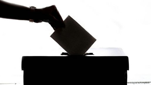 Ein Wahlschein wird in die Wahlurne eingeworfen