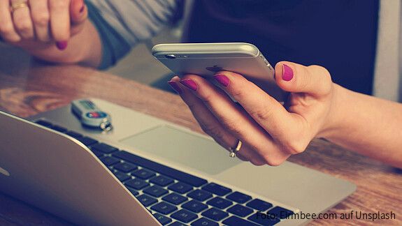 Europa digitalisieren, Verwaltung stärken Eine Person sitzt vor einem Laptop und hat ein Handy in der Hand