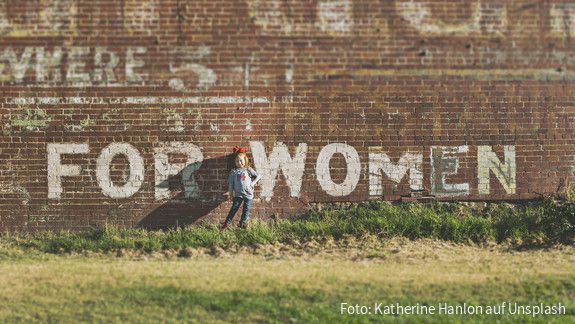 Ehrgeizige EU-Roadmap für Frauenrechte gefordert Ein Mädchen steht vor einer Wand auf der For Women steht