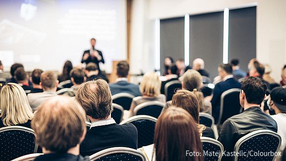 Symbolfoto zum Thema "VBLkongress": Zu sehen sind Menschen in einem Saal, die an einer Tagung teilnehmen.