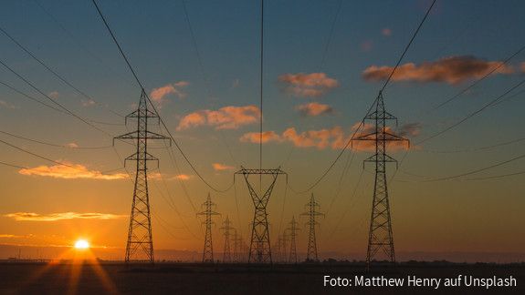 Die Strombank - Ideen zur Reform des Energiemarkts Stromleitungen und Strommasten in der Morgendämmerung