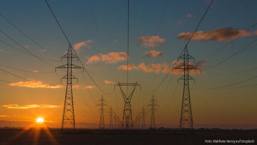 Stromleitungen und Strommasten in der Morgendämmerung