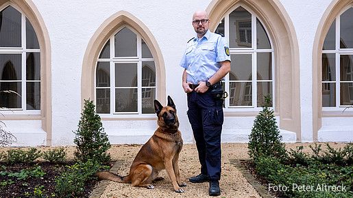 Foto zum Thema Ausbildung zum Justizvollzugsbeamten: Zu sehen ist Philipp, der seinen beruflichen Werdegang schildert, mit seinem Diensthund Balin.