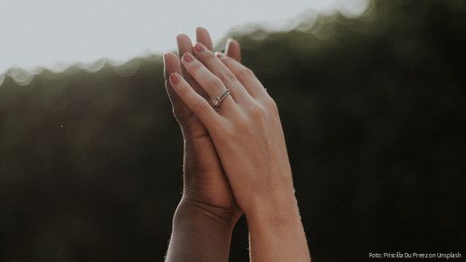 Hände unterschiedlicher Hautfarben halten einander