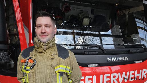 Foto zum Thema "Feuerwehrmann werden": Zu sehen ist Lucas, der vor einem Feuerwehrauto steht und im Jobkompass Einblicke in seinen Beruf gibt.