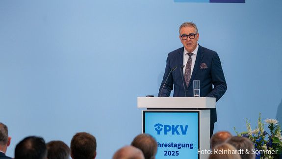 Fotos der PKV Jahrestagung 2025 am 05.06.2025 in Berlin  Ein Mann in Anzug steht hinter einem Rednerpult und spricht in ein Mikrofon