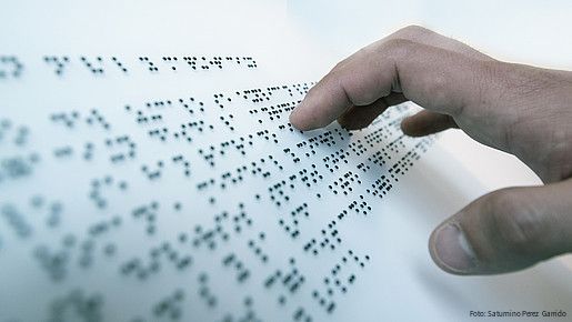 Hand auf Blindenschrift