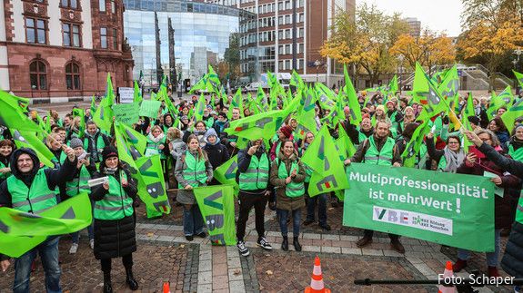 Viele Menschen mit hellgrünen Fahnen demonstrieren auf dem Dortmunder Friedensplatz