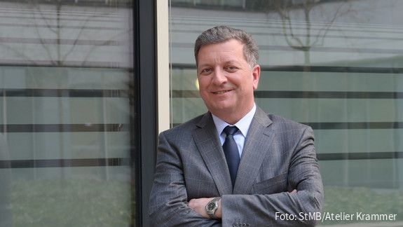 Foto von einem Mann im Anzug vor einer Glaswand