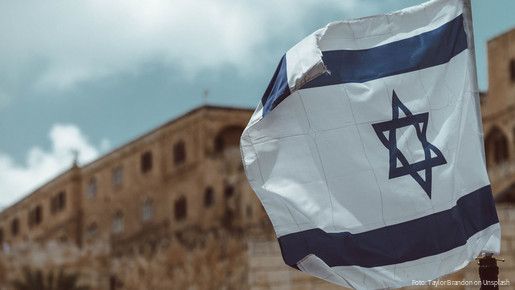 Israelische Fahne mit altem Gebäude im Hintergrund
