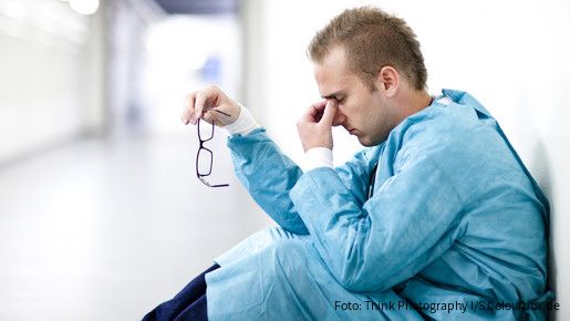 Personal des öffentlichen Gesundheitsdienstes Arzt sitzt erschöpft am Boden