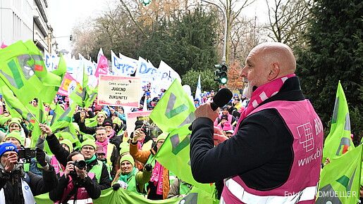 Ein Mann spricht auf einer Demo in ein Mikrofon