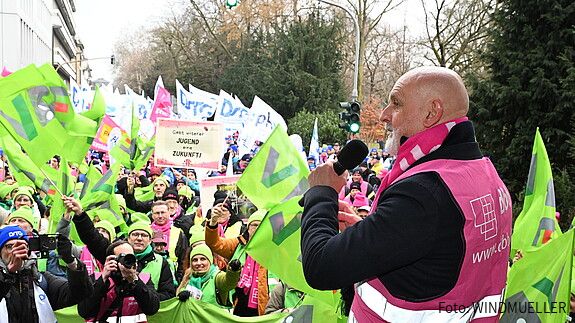 Ein Mann spricht auf einer Demo in ein Mikrofon