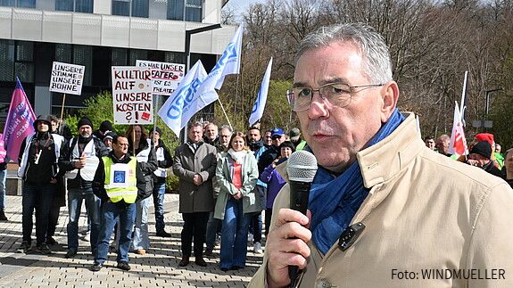 Das Foto zeigt Demonstrierende in Wiesbaden am 25. März. 2026. Sie tragen Streikwesten und halten Transparente.