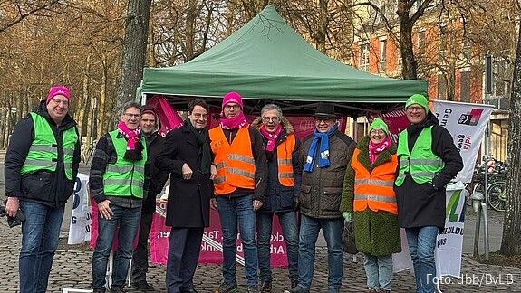 Menschen in bunten Warnwesten demonstrieren auf einem öffentlichen Platz