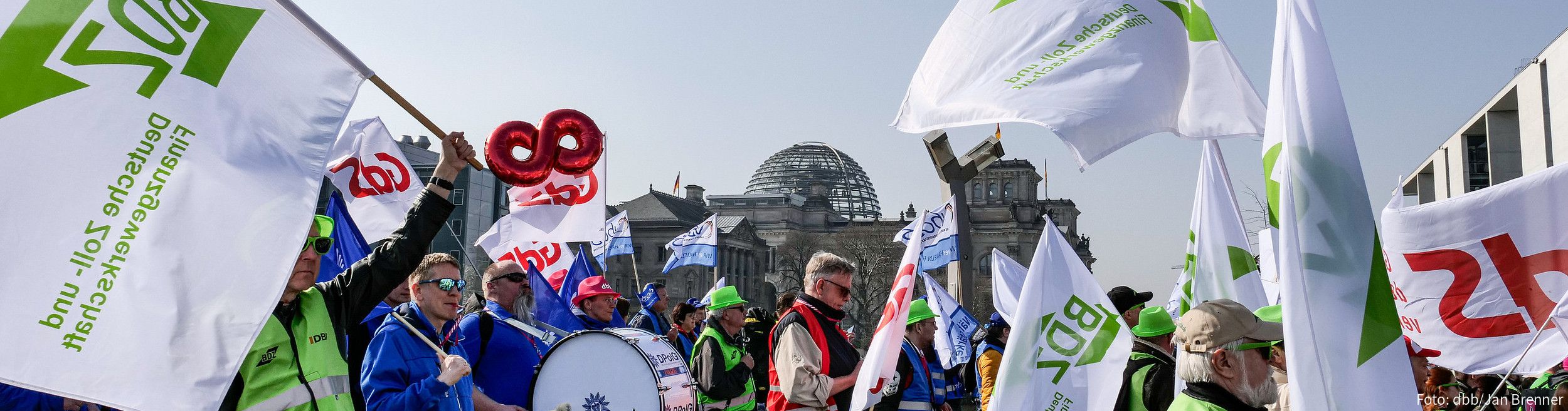 Demonstrierende Laufen mit Pauken und bunten Fahnen durch die Berliner Innenstadt