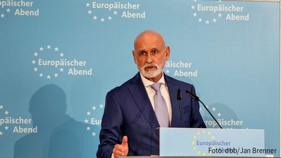 Ein Mann in Anzug steht hinter einem Rednerpult und spricht in das Mikrofon.