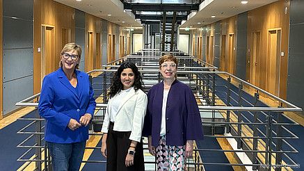 Drei Frauen stehen in einem Korridor und blicken in die Kamera