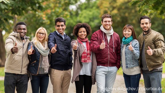 Junge Menschen halten den Daumen nach oben